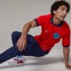 Nike Men's England Dri-Fit Away Stadium Jersey - Challenge Red/Blue Void -Optimal Sportswear Store FA22 PDPplus DN0685 600 BN01 DES
